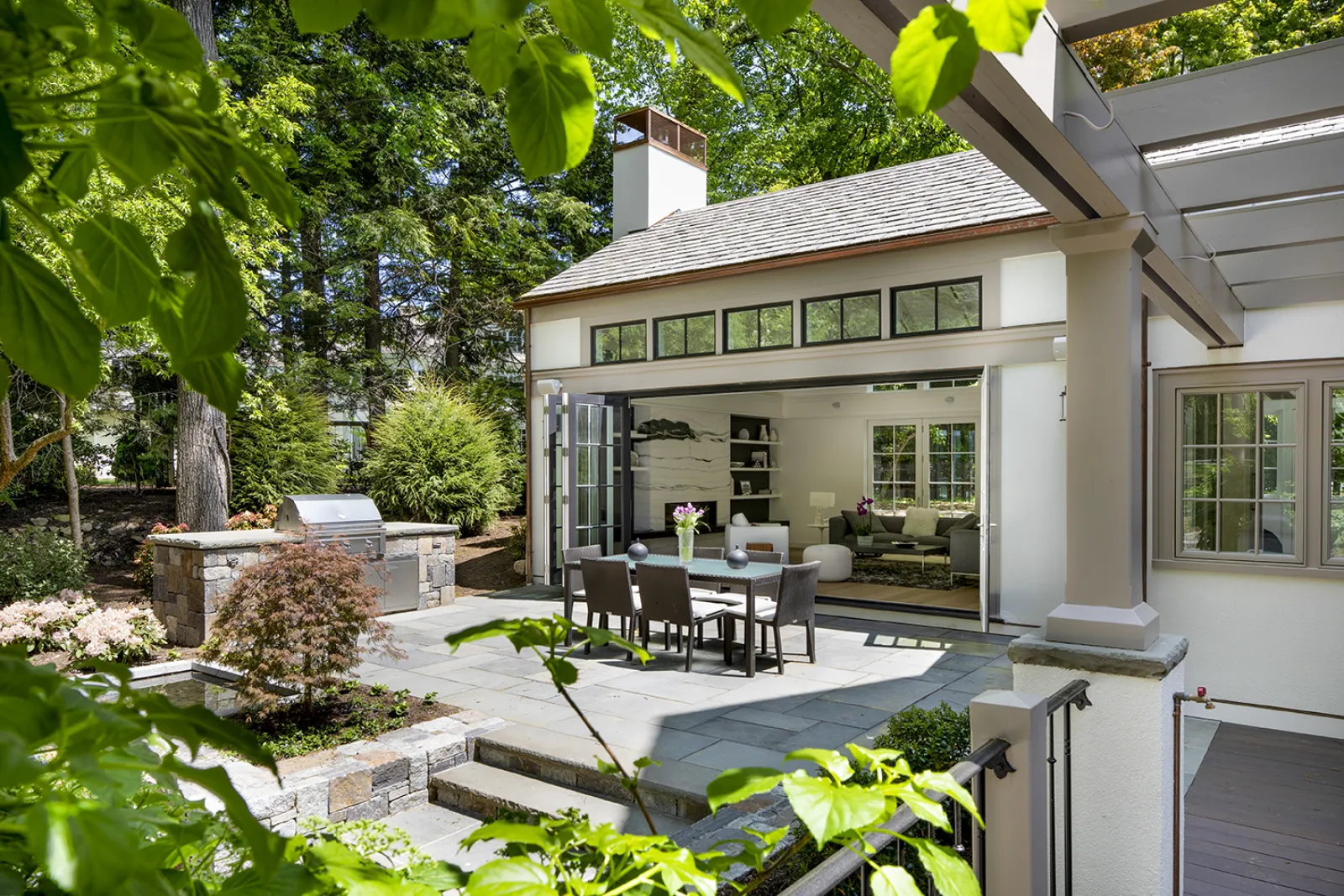 outdoor view of house with bbq wall and open doors