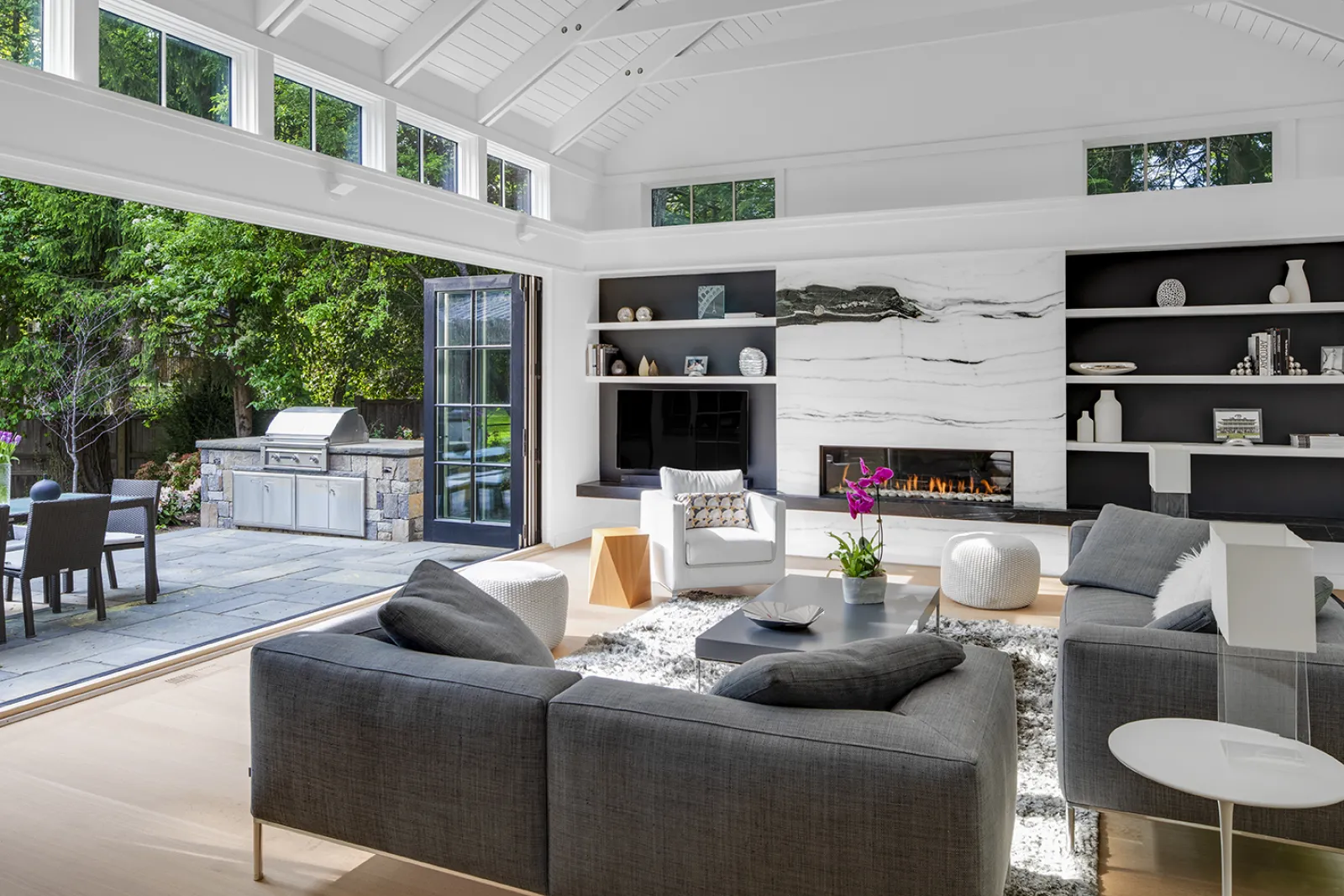family room with accordion doors and modern marble fireplace